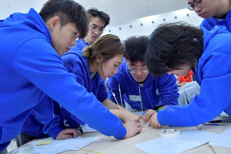 一群人看着桌子上中度可信度描述已自动生成